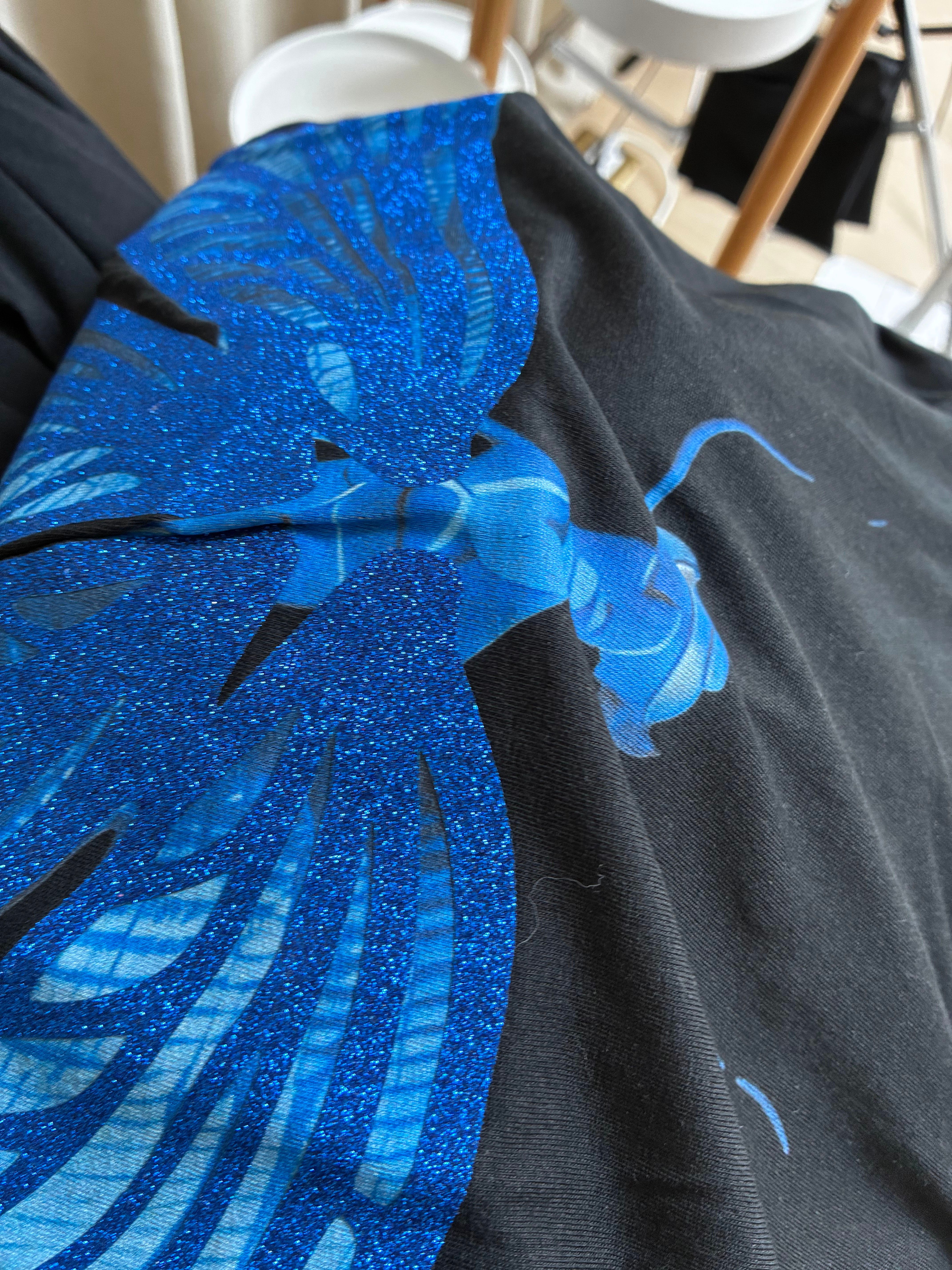 Glitter Heat Transfer Vinyl — blue butterfly wings showing the coarse sparkle grain