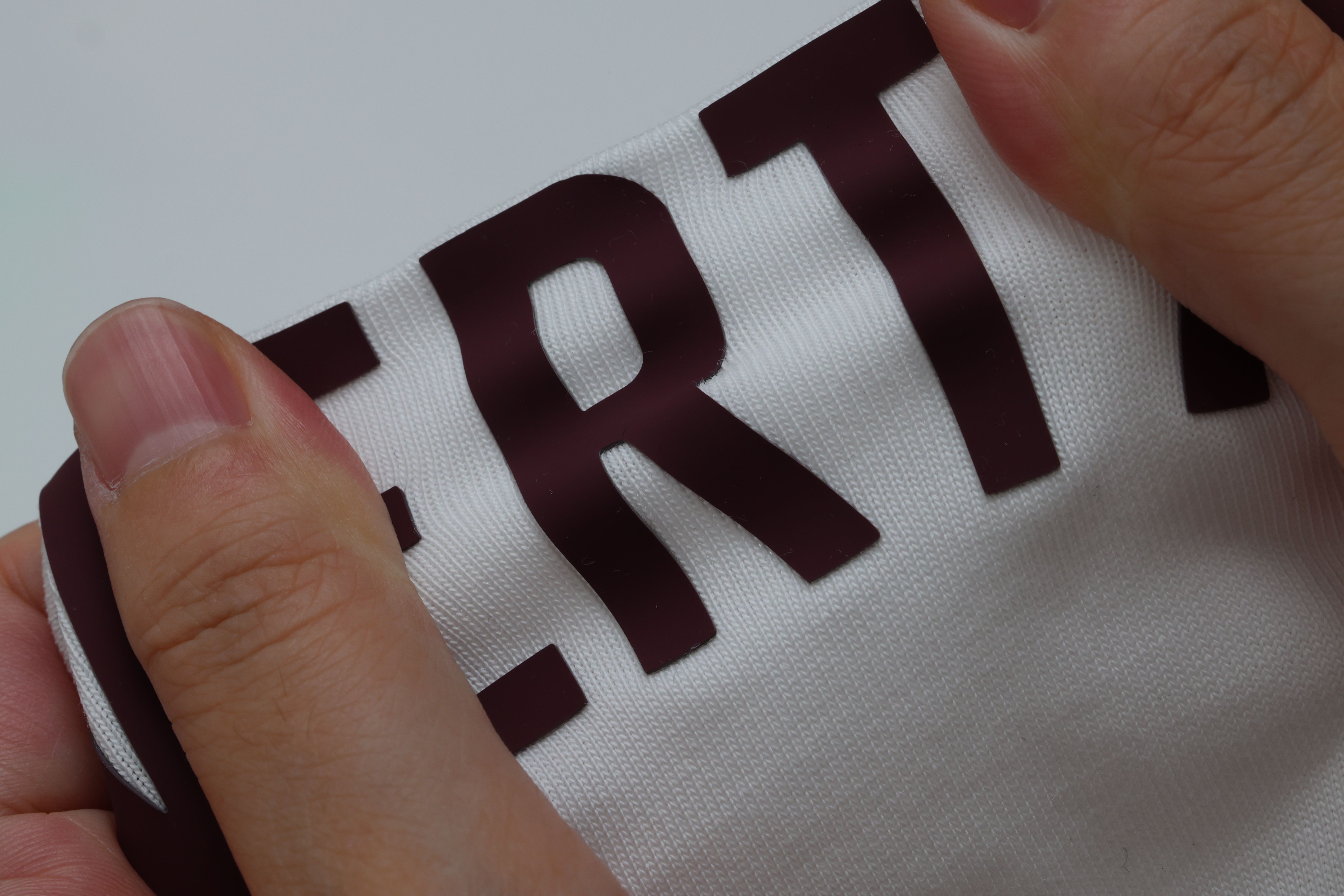 Velvet Heat Transfer Vinyl — deep burgundy soft-touch lettering on white knit, pinched to show the raised pile