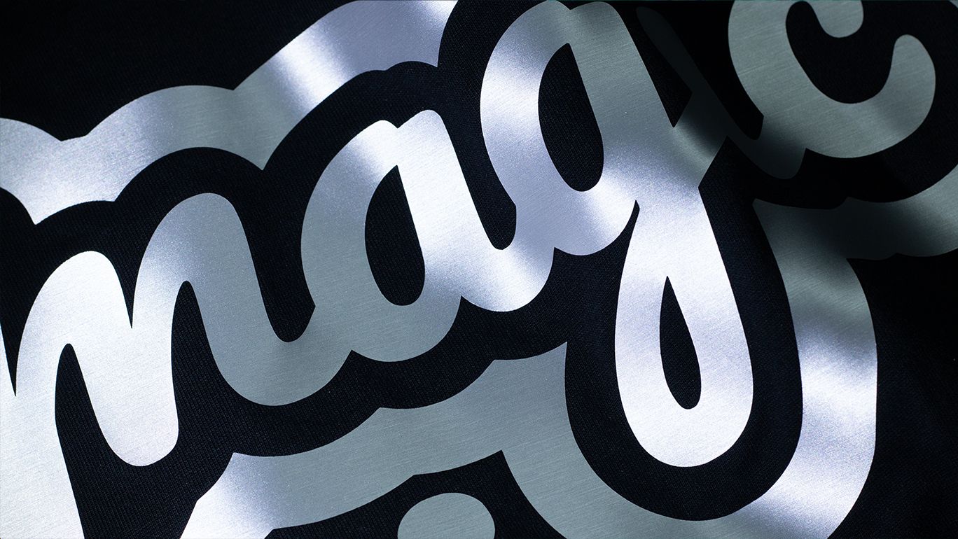 Metallic Heat Transfer Vinyl in silver — script lettering on a black tee, catching the light