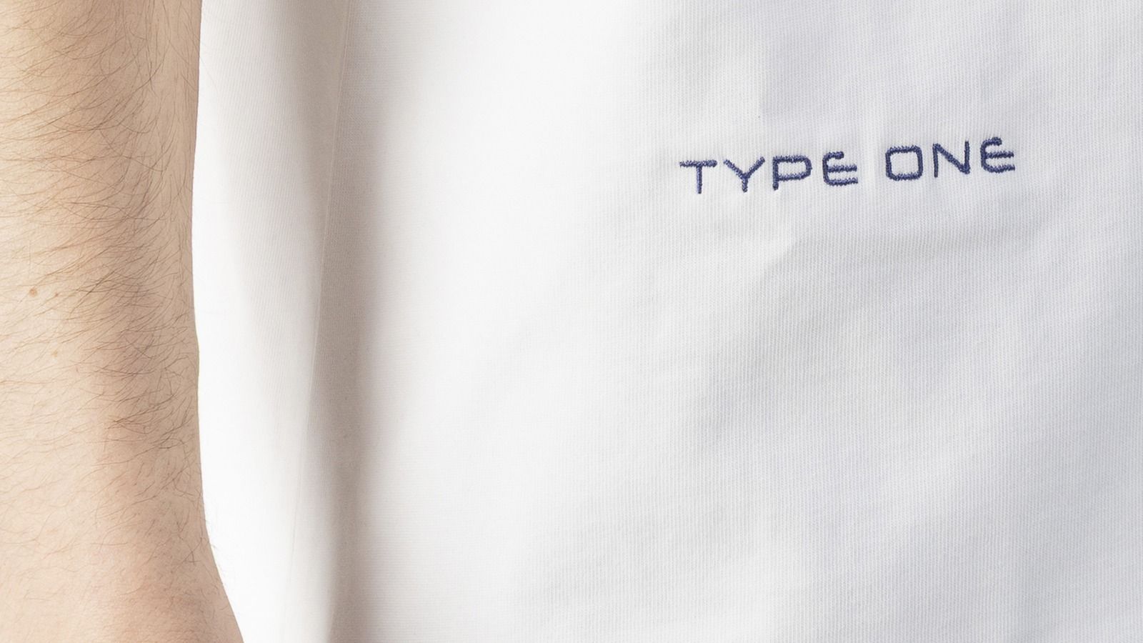 PODpartner 15-color Embroidery close-up: stitched depth detail on white cotton T-shirt showing thread-built dimensionality, the luxury label signal that no other decoration process can replace