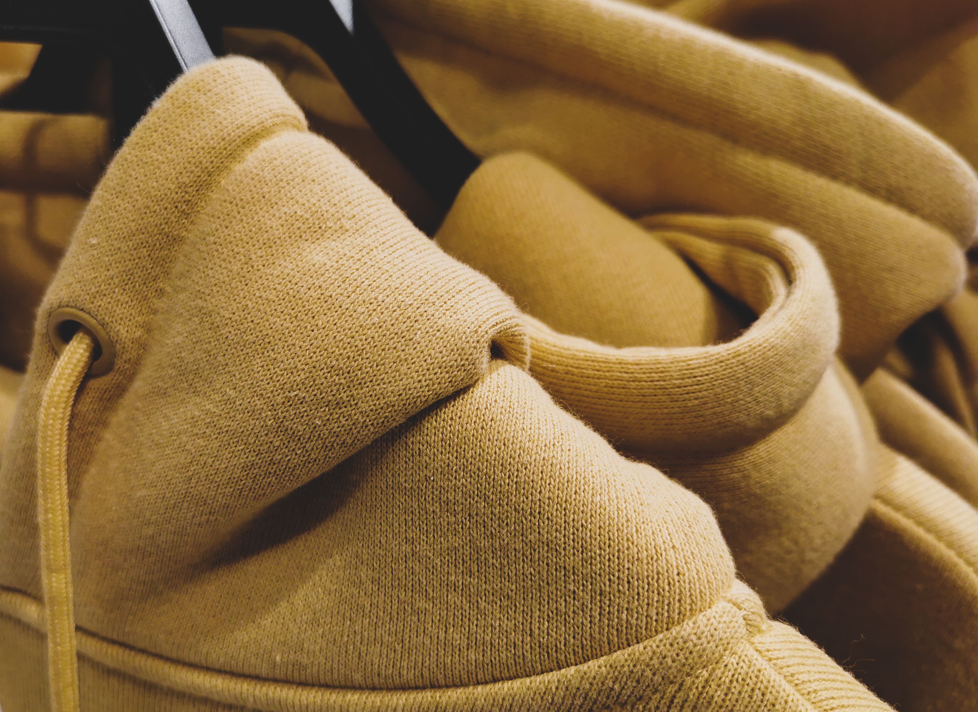 Close-up of heavyweight hoodies on hangers in a store