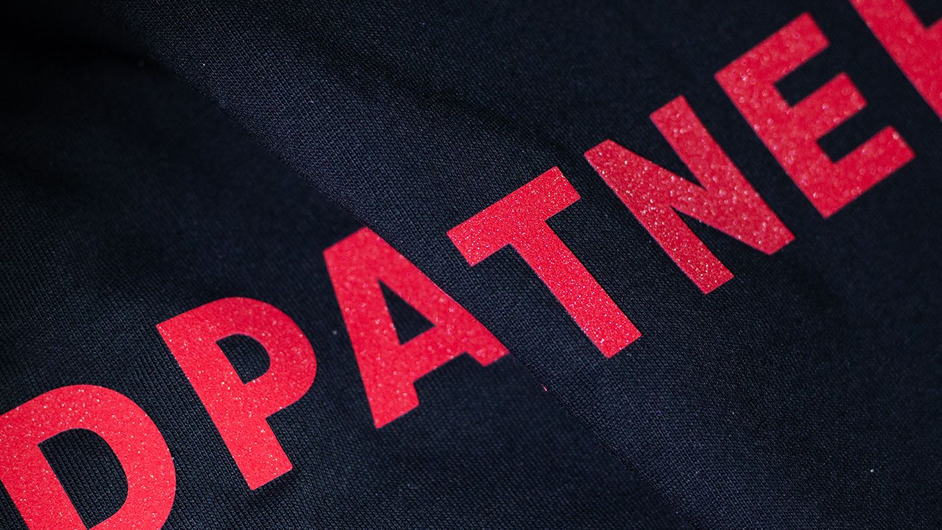 Premium Silicone HTV raised logo detail in red on dark heavyweight cotton hoodie, Fear of God Essentials silicone print alternative by PODpartner