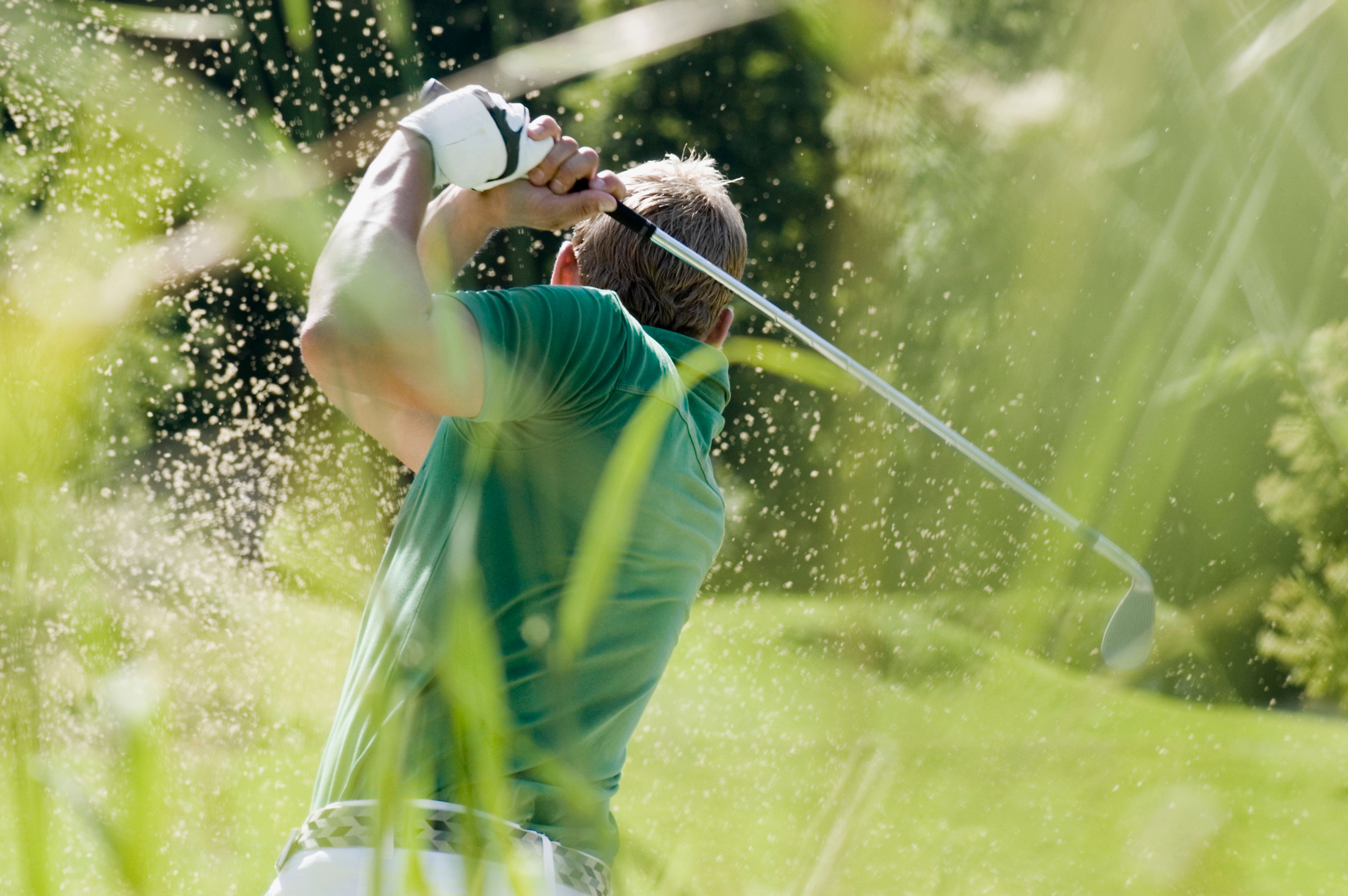 Golf player seen from behind wearing a cap