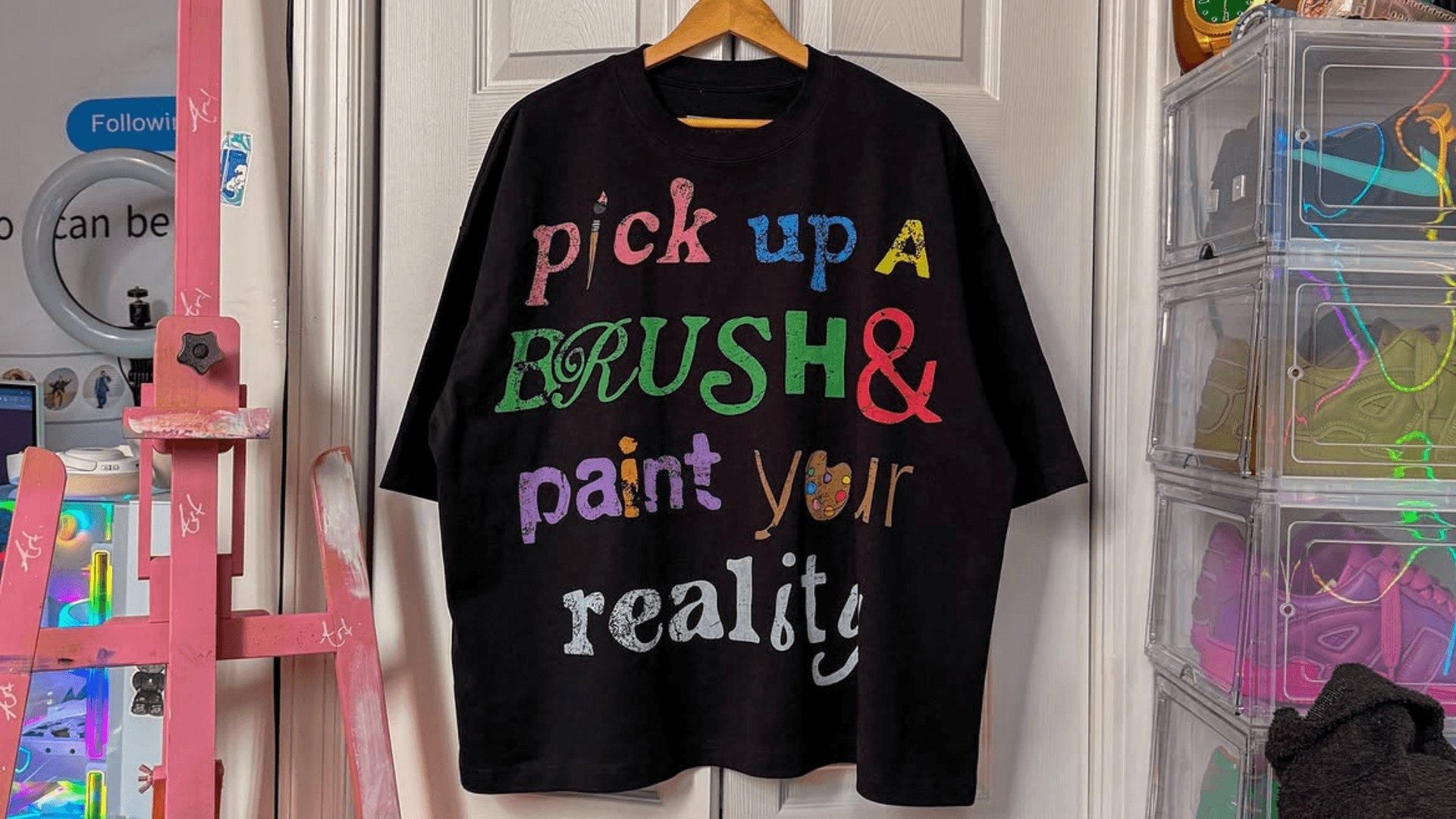 Oversized heavyweight t-shirt with multi-colour print hanging on a door