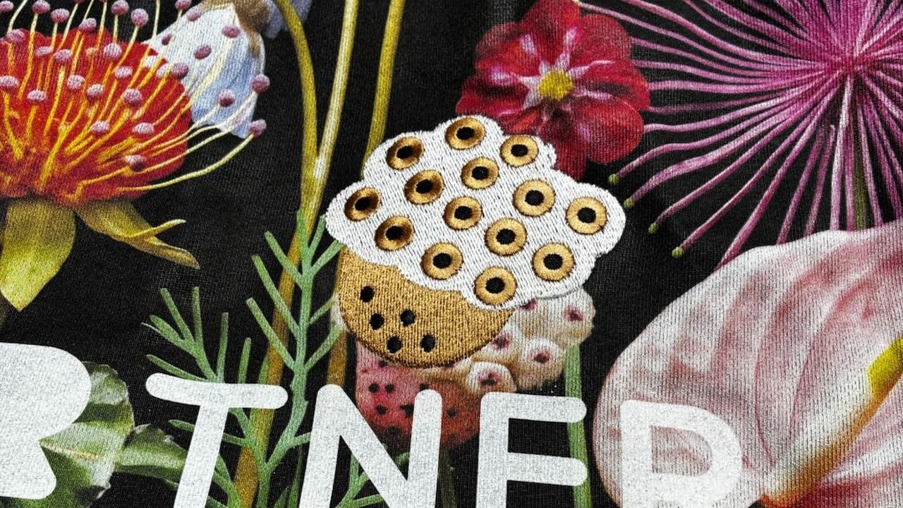 PODpartner garment showing multiple decoration techniques on one piece — floral all-over print, flat embroidery, and 3D puff embroidery combined in a single production pass